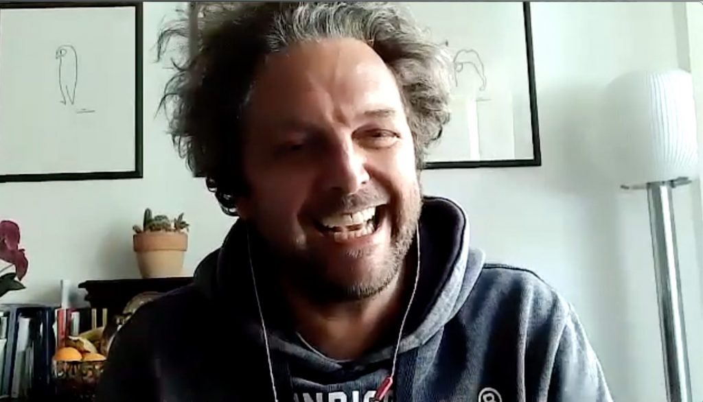 Un frame dell'intervista di Quoziente Humano al comico Antonio Ornano, sorridente nella sua postazione di lavoro 